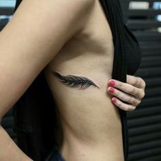 a woman's stomach with a feather tattoo on the side, and an instagramtion