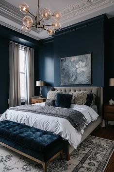 a bedroom with dark blue walls, white bedding and an upholstered bench