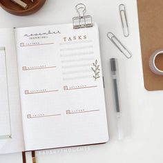 an open planner book sitting on top of a desk next to a cup of coffee