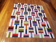 a quilt is laying on the wooden floor