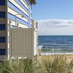 a beach hut next to the ocean on a sunny day