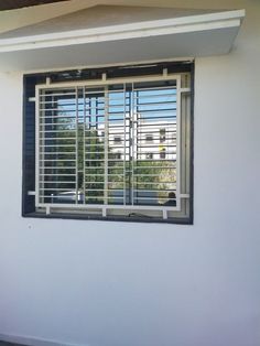 a white wall with a window that has blinds on it