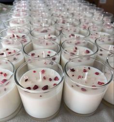 many glasses filled with white candles on top of a table