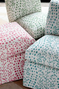 two colorful footstools sitting on top of a wooden floor next to each other