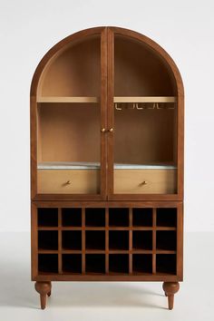 a wooden display case with wine bottles in the front and bottom shelves on both sides