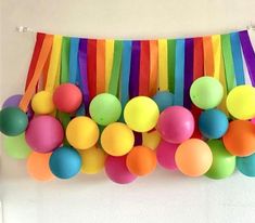 colorful balloons and streamers are hanging on the wall