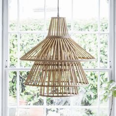 a bamboo lamp hanging from a window sill