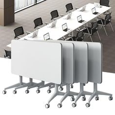 three tables and four chairs with laptops on them in an empty office setting,