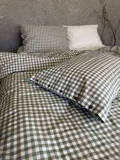 an unmade bed with two pillows and a pillow case on the bottom one is black and white checkered