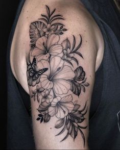 a black and white flower tattoo on the left arm, with a butterfly flying over it