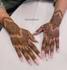 two hands with henna tattoos on them