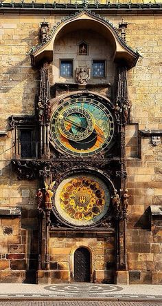 an ornate clock on the side of a building with sunflowers painted on it