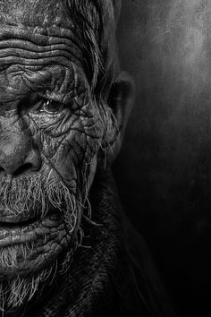 black and white photograph of an old man's face with wrinkles on it