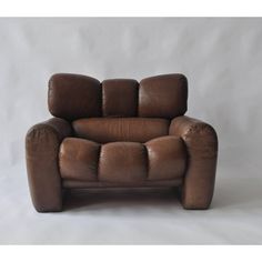 a brown leather chair sitting on top of a white floor