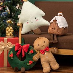 three stuffed animals sitting next to each other in front of a christmas tree and presents