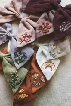 several different colored ties with embroidered flowers on them