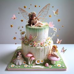 a cake decorated with fairy figurines and flowers