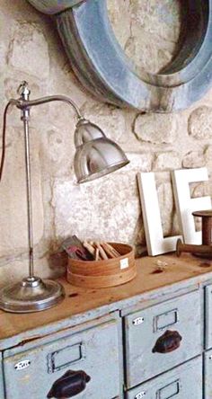 an old dresser with drawers and a lamp on top