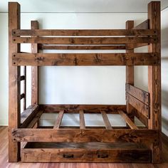 a wooden bunk bed sitting on top of a hard wood floor