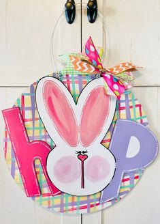 a door hanger with an easter bunny design on it's face and the letter h