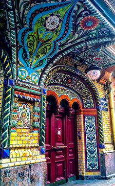 an ornately painted building with red doors