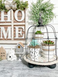 a birdcage filled with potted plants on top of a table