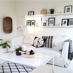 a living room filled with white furniture and decor