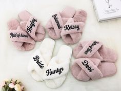 four pairs of slippers with names on them sitting next to a book and flowers