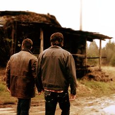 two men standing in front of an old building with the words hell house written on it