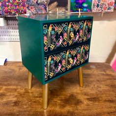 a green cabinet with colorful designs on it