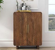 a wooden cabinet sitting next to a potted plant