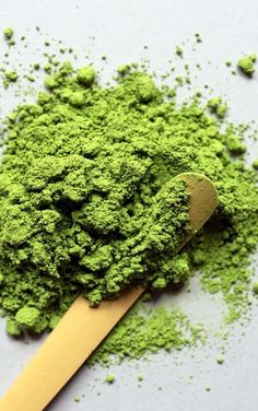 a wooden spoon filled with green powder