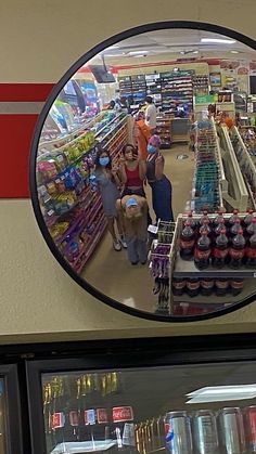 a mirror reflecting people shopping in a grocery store