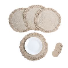 four round placemats and two plates on a white background