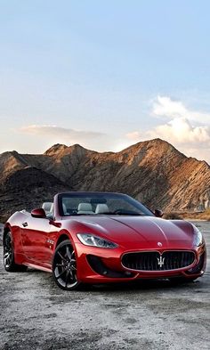 a red masera parked in front of mountains