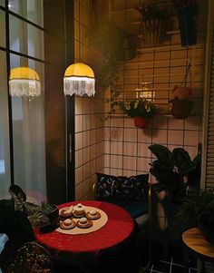 a red table topped with donuts next to a window