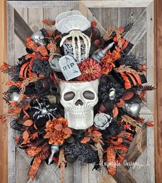 a halloween wreath with a skull, spider web and pumpkins