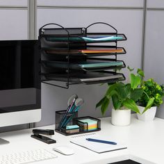 an office desk with a computer monitor, keyboard and pen holder