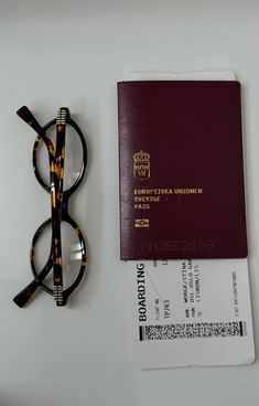 a passport, glasses and visa sitting on a table next to a pair of eyeglasses