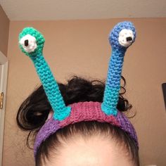 a woman with her hair in a crocheted bunt and two googly eyes