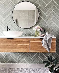 a bathroom with a sink, mirror and potted plant