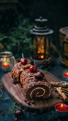 an apple cinnamon roll on a cutting board surrounded by candles and other holiday decor items