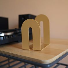 there is a small wooden letter on the table next to a turntable and record player