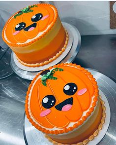 two decorated cakes sitting on top of each other in the shape of jack o lantern faces