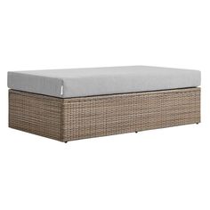 an outdoor wicker ottoman with grey cushions and a gray cushion on the bottom side