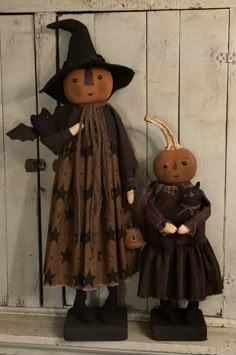 two scarecrows are standing next to each other in front of a white door