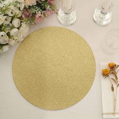 a place setting with flowers and wine glasses on the table, along with napkins