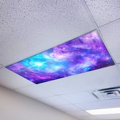 the ceiling in an office is decorated with purple and blue galaxy paint on it's walls