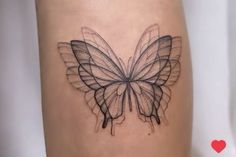 a black and white butterfly tattoo on the thigh