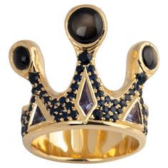 One of a Kind Crown Ring encrusted with blue sapphires and topped with Black Star Sapphires. This sculptural ring makes a bold statement and is a wearable work of art. If you like this ring, check out the companion piece in our collection. Listing Title: Hand carved Sterling Silver with Gold Ring on Ring • Hand carved 10 karat yellow gold • 3 x Black Star Sapphire, cabochon • Pavé set blue sapphires, 1.2 Approximate Total Carat weight • Ring size: 10 • Total weight: 19.84 grams • Made in Canada Niagara On The Lake, Sculptural Ring, Star Sapphire Ring, Crown Ring, Star Sapphire, Diamond Settings, Black Star, Quality Diamonds, Cocktail Rings